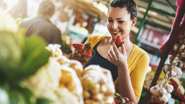 British Food and Drink Fortnight woman smiling eating strawberry